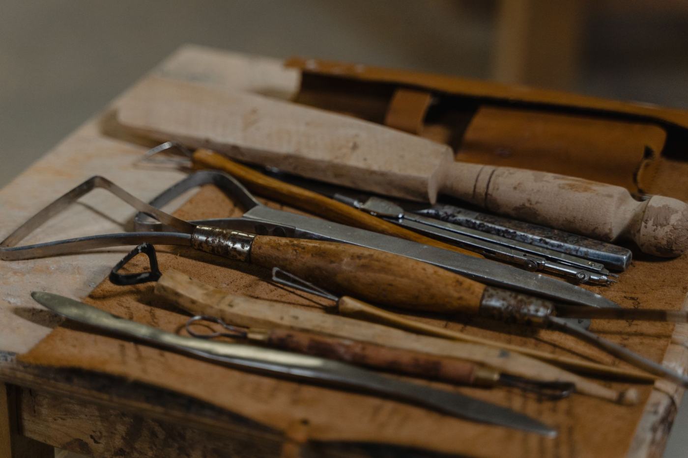 Hand carving tools laid out on a workshop bench